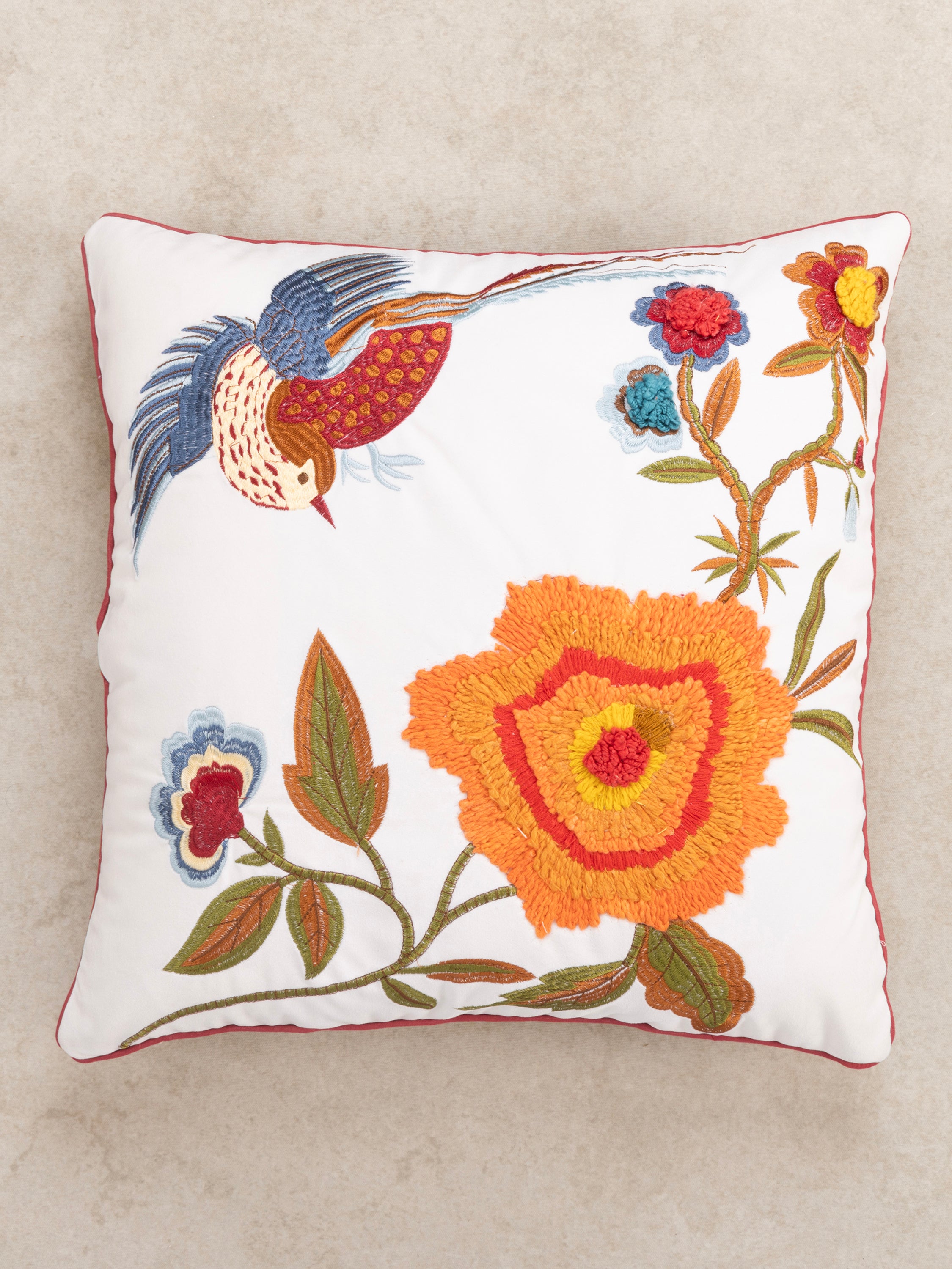 Decorative cushion with intricate embroidery of a flying bird and oversized orange flower, bringing nature-inspired elegance to your home decor