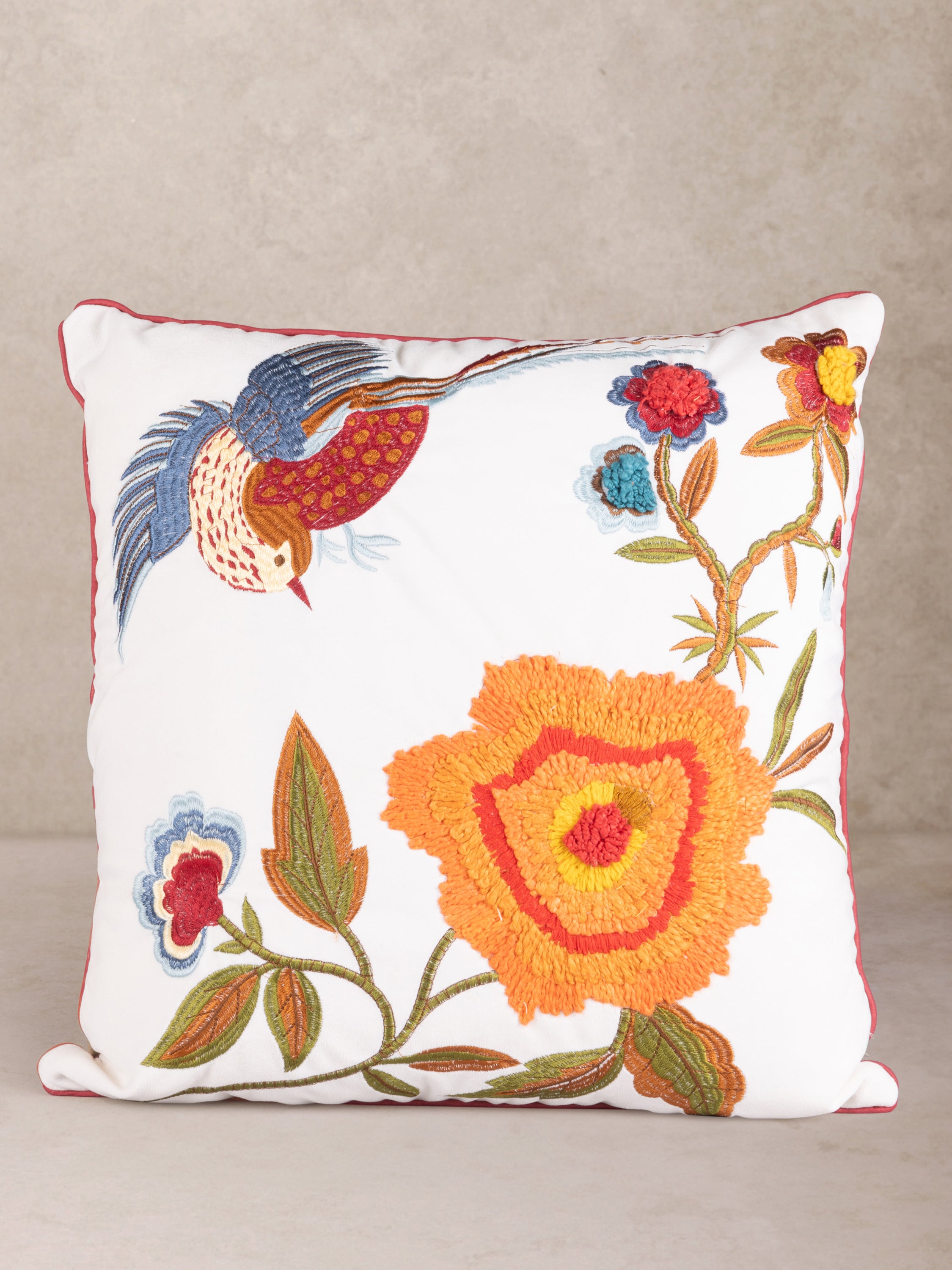 Square embroidered throw pillow featuring a colorful bird and vibrant floral design on a white background, perfect for adding a bold accent to any space