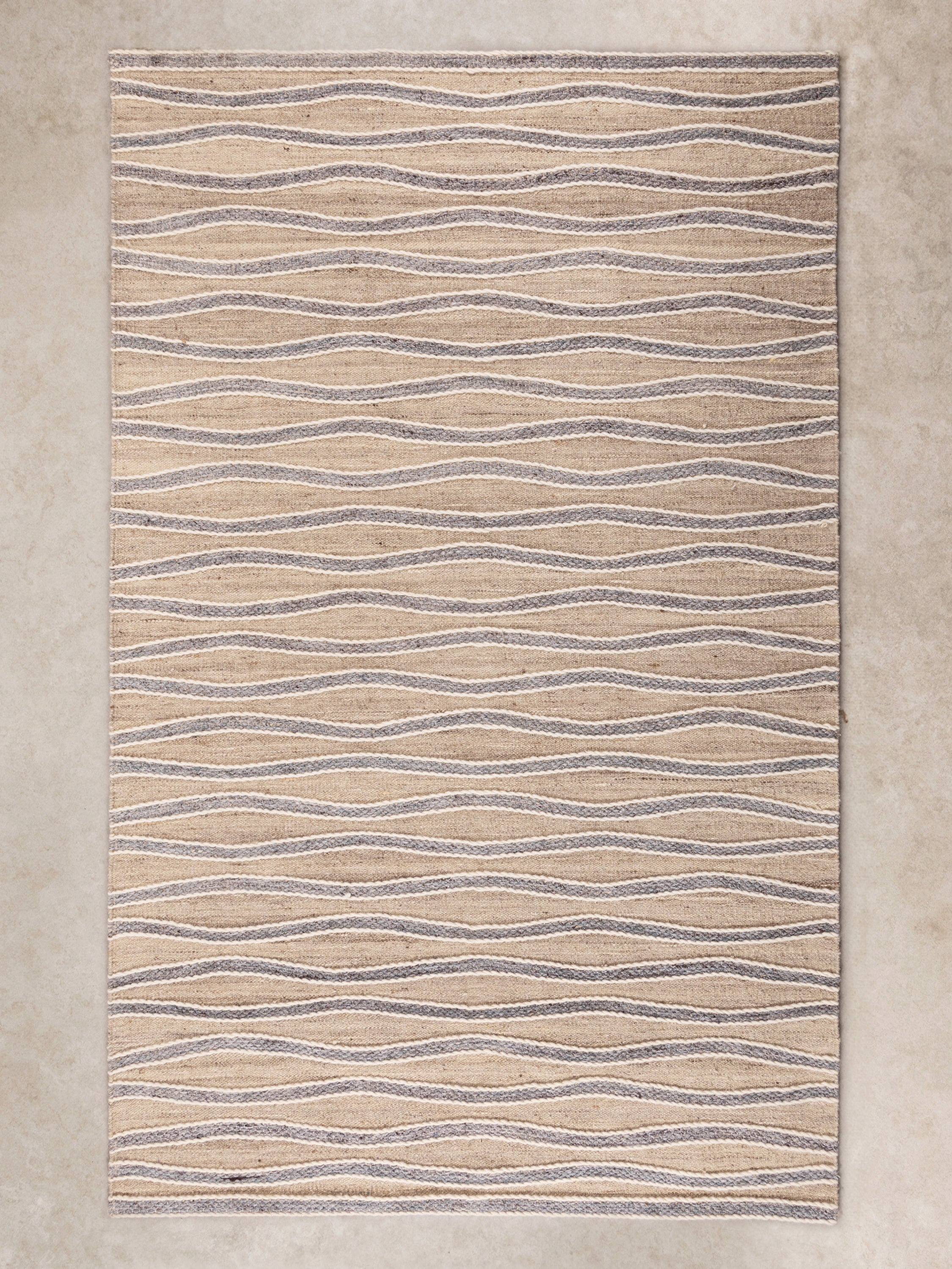 Handwoven wool and jute flatweave rug with a modern wavy pattern in neutral tones